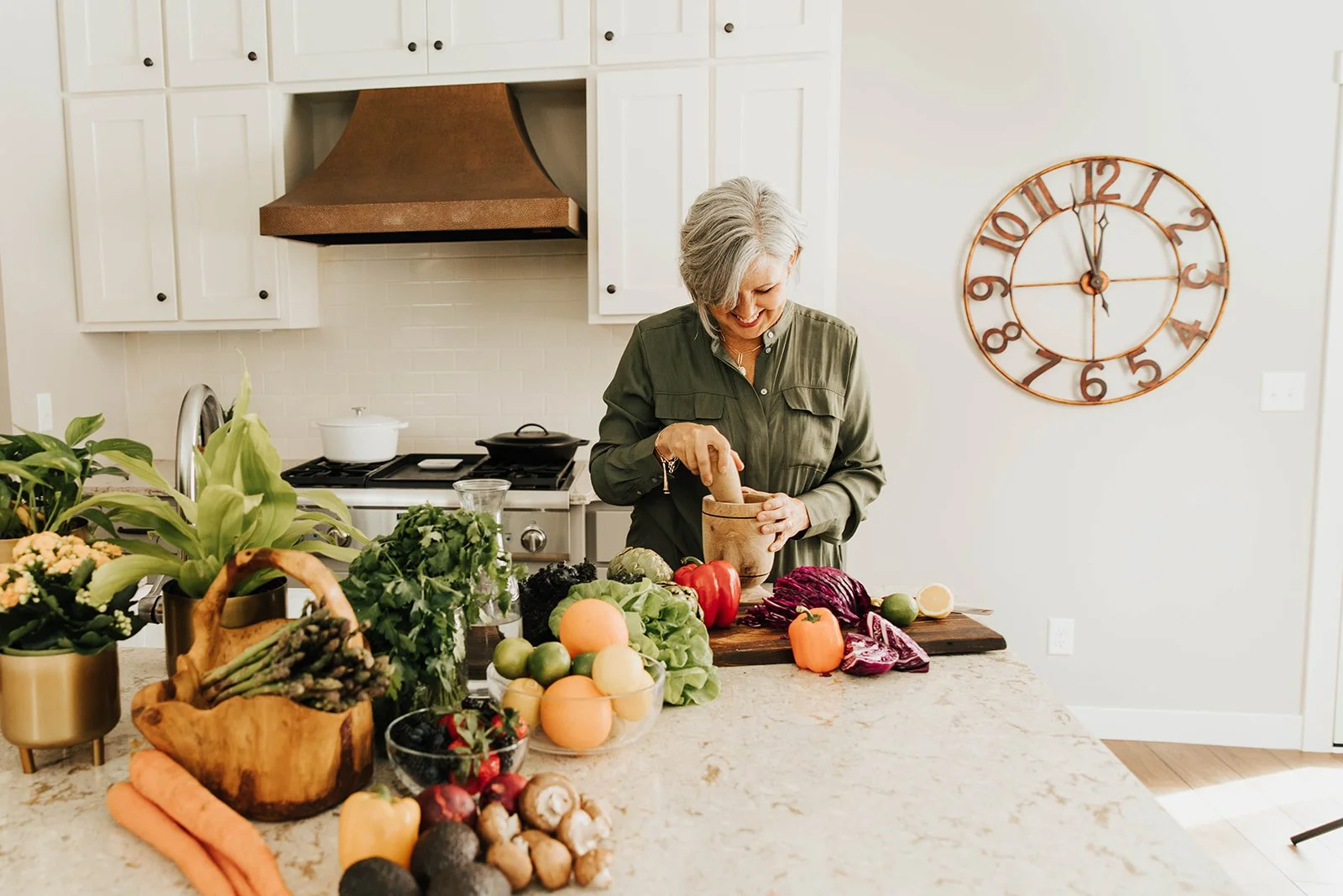 a woman is cooking with colorful vegetables in her kitchen