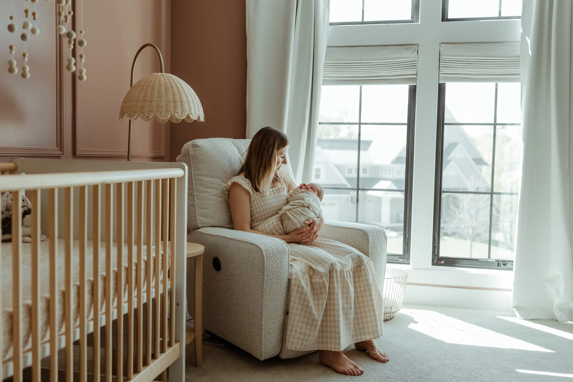 a mom is rocking her baby in her nursery