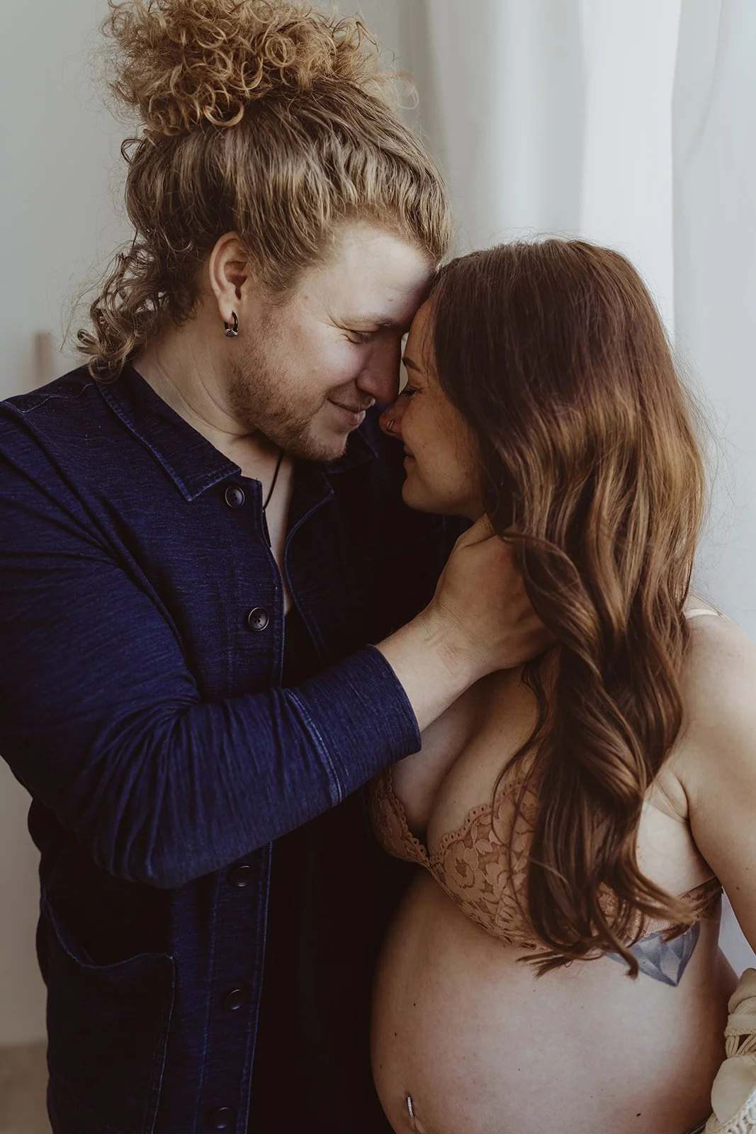 couple is embracing during a maternity photo shoot with amg photography