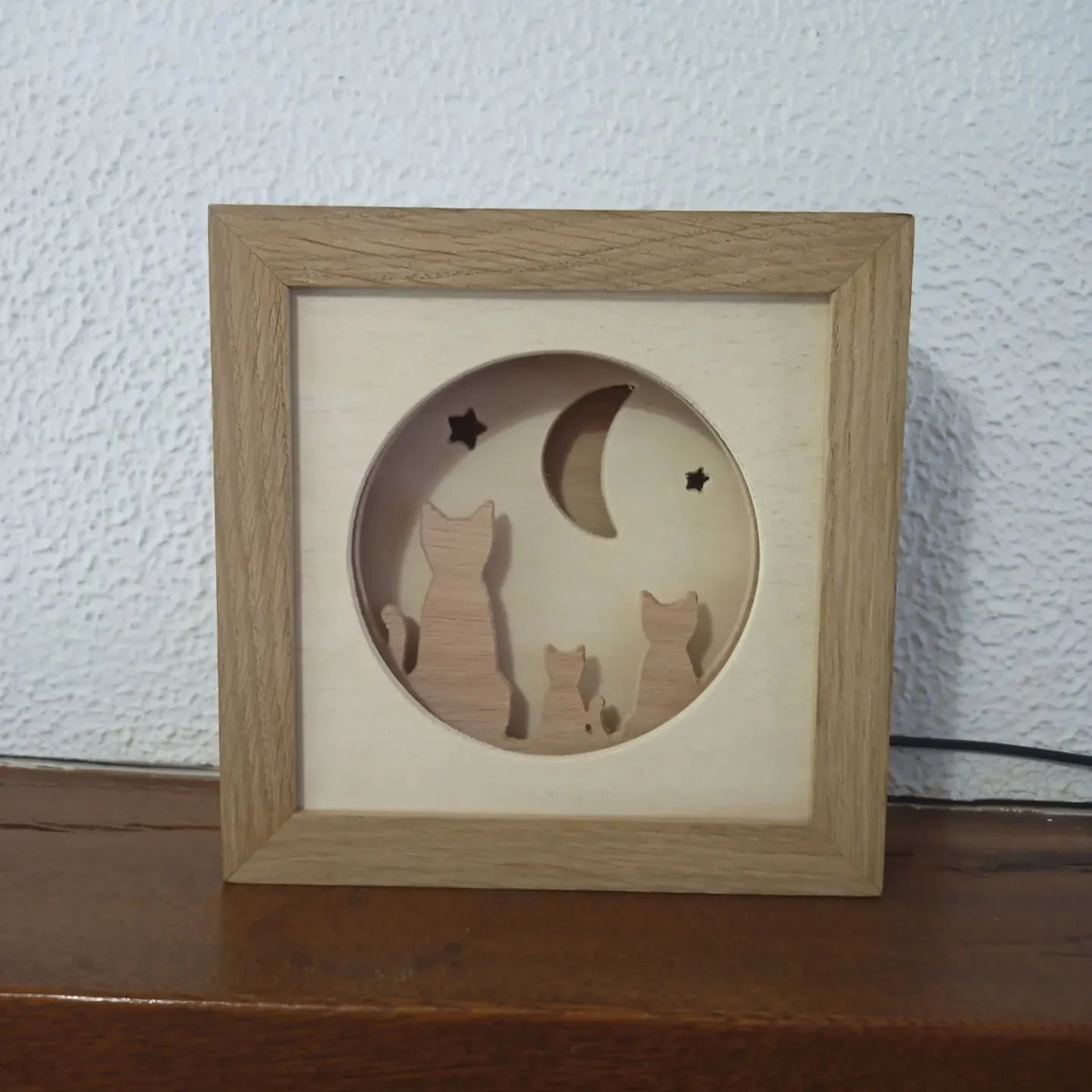 Mon design avec trois chats sur les toits regardant la lune! Cette veilleuse a &eacute;t&eacute; faite pour &ecirc;tre aussi jolie &eacute;teinte que allum&eacute;e gr&acirc;ce a l'alternance des types de bois et un cadre &eacute;pais en ch&ecirc;ne 