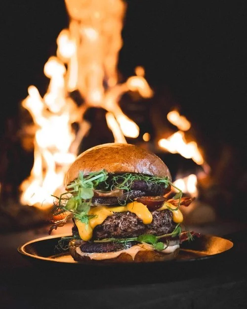 Gourmet burger with local ingredients served by open fire at Dovrefjell Lodge restaurant, Norway