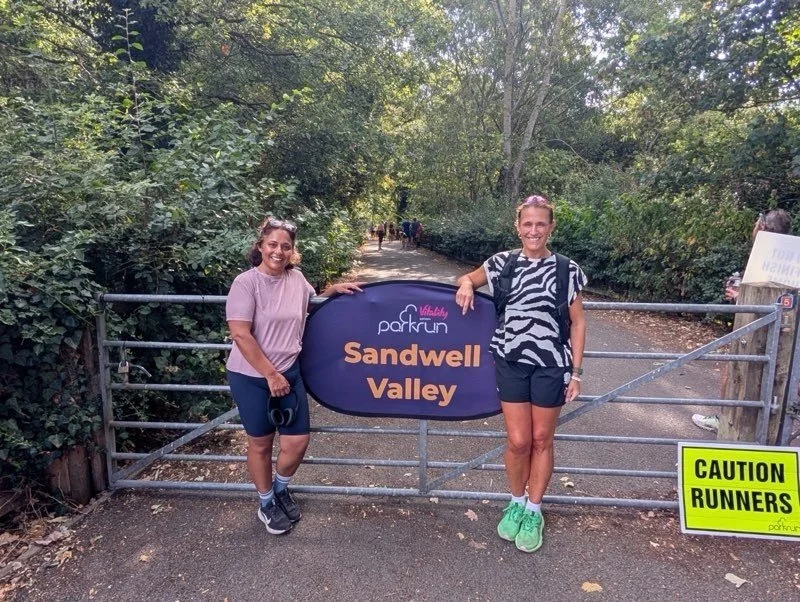 Two female runners after a race, smiling in Sandwell Valley