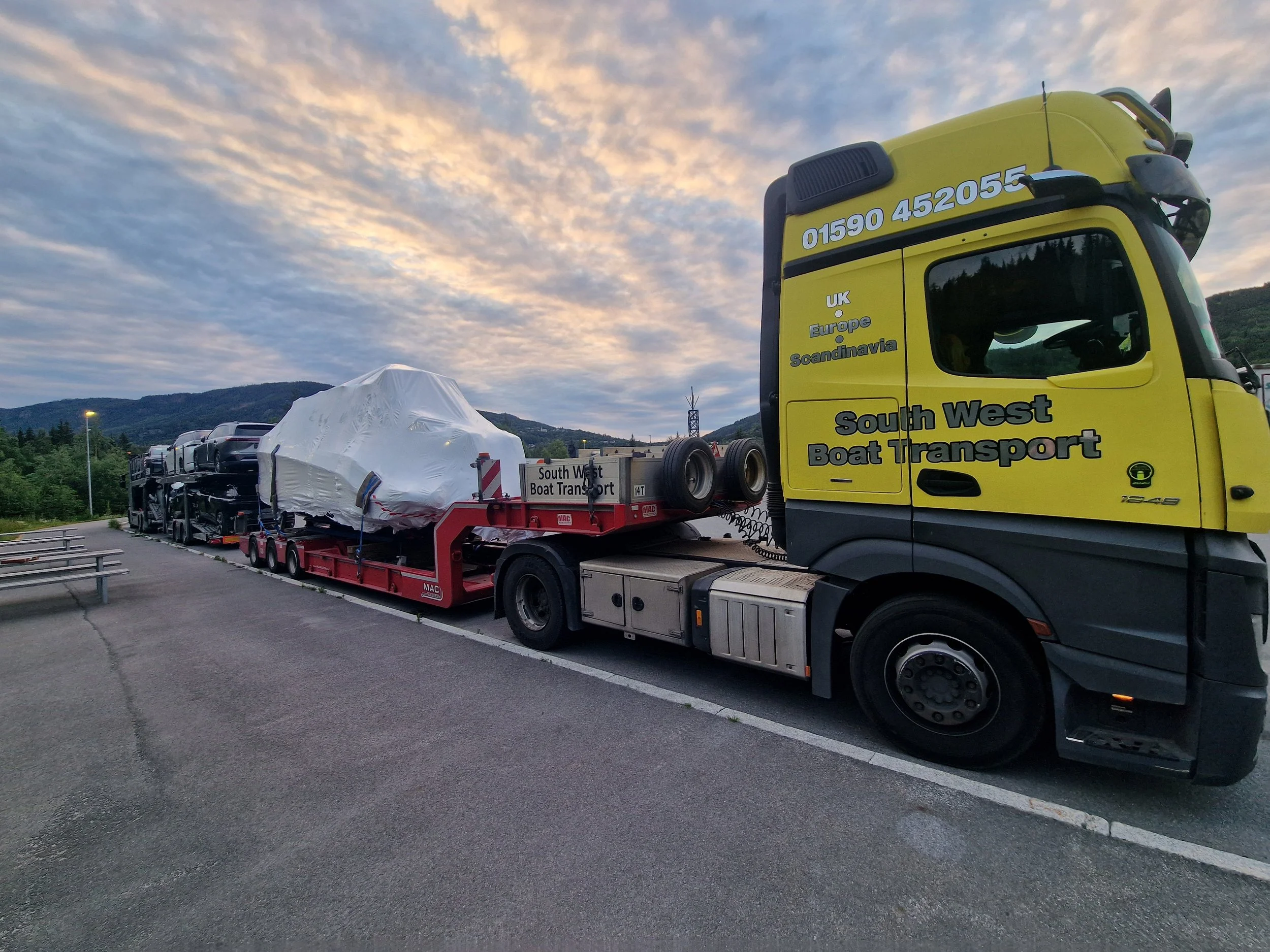 wrapped motor boat on a low loader truck