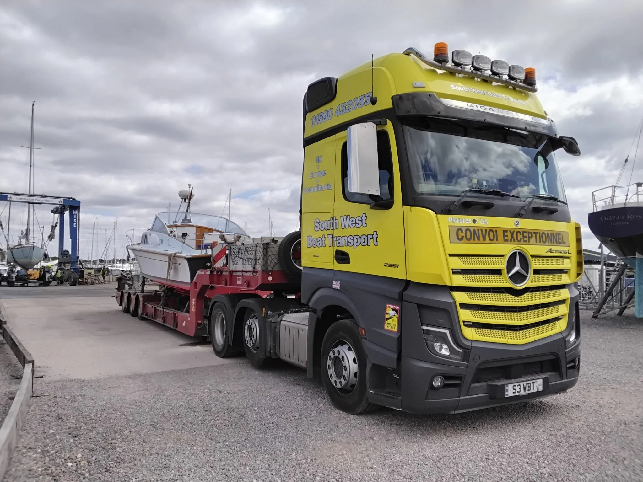 classic motorboat on a low loader trailer  pull by a truck