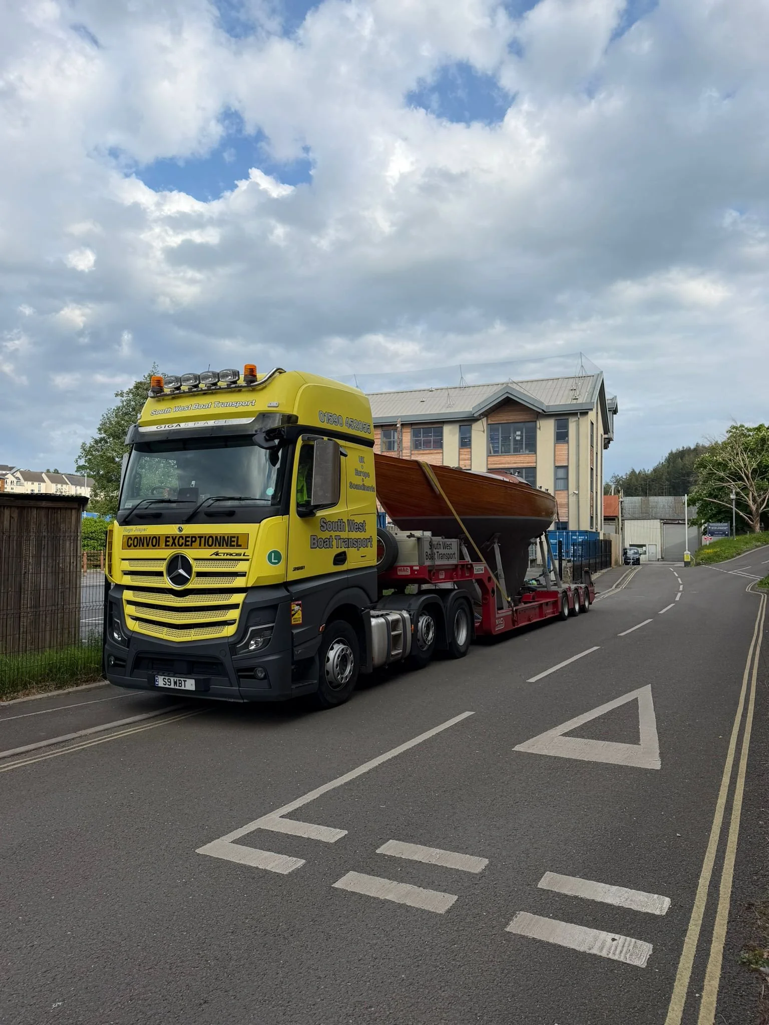 long keel sail boat on a low loader truck