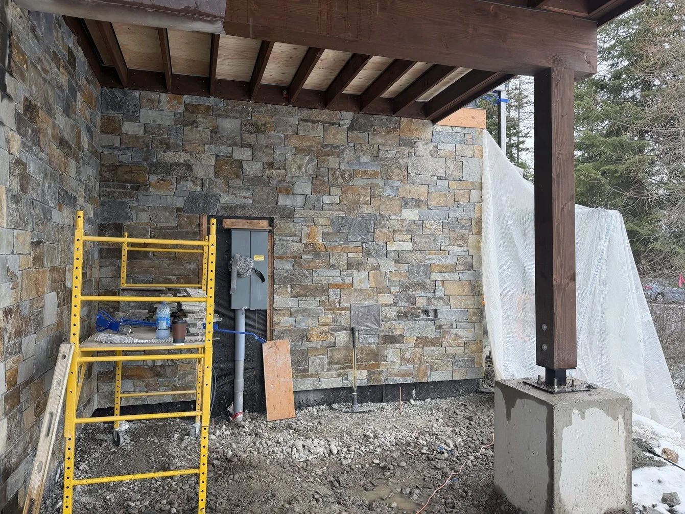 Stone siding, added piece by piece, on the latest luxury custom home in Bigfork, Montana, by Hill Builders.