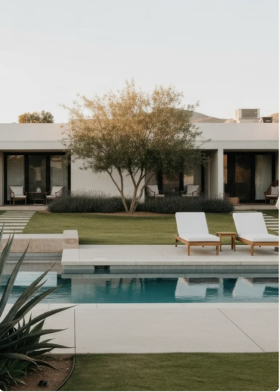 View of backyard with swimming pool, lounge chairs, and modern house with large windows and a tree