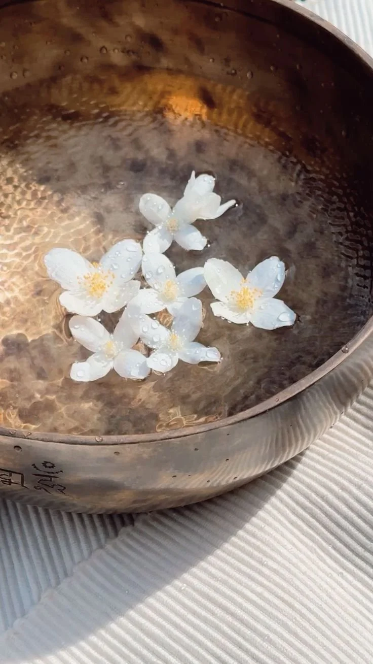 Tibetan singing bowl filled with fresh flowers as a ritual voice offering