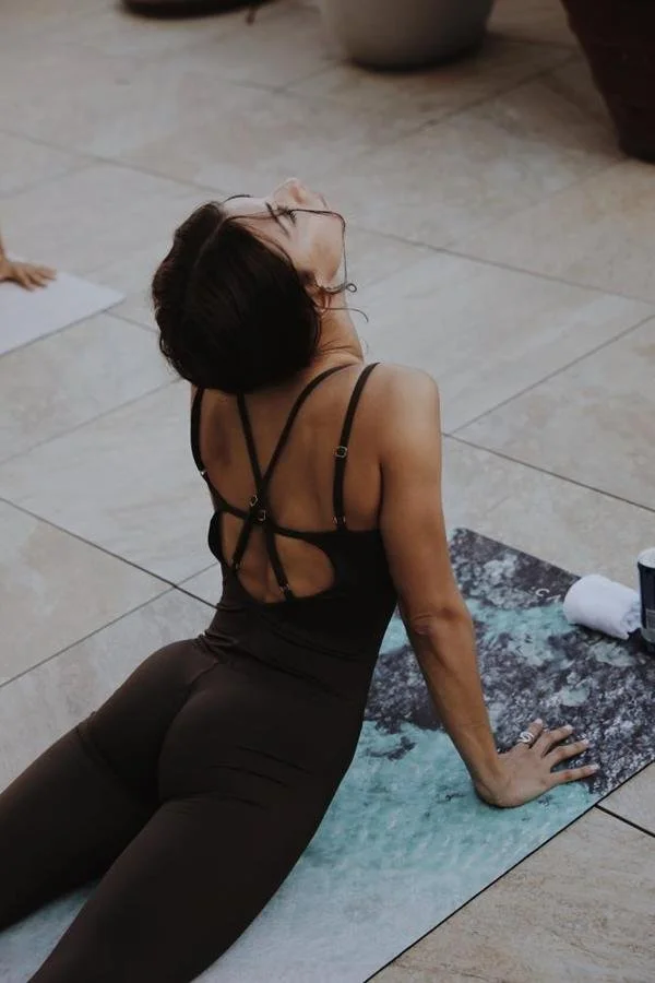 Alba Cañizares practising an upward-facing yoga backbend on the terrace of a suite at ME Barcelona during a sunset photoshoot.
