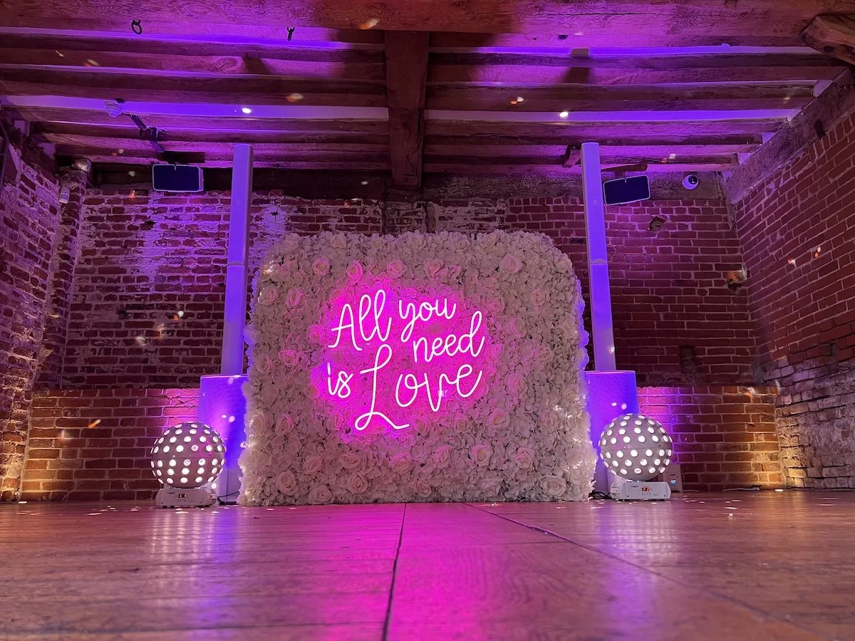 A disco set up in a ban with a neon sign saying All you need is lovehttps://www.cuttingdiscos.co.uk/