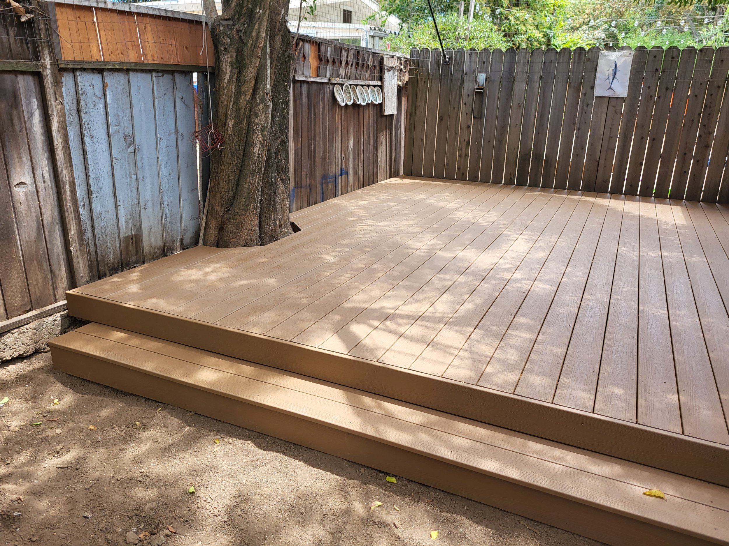 Composite deck installation with cutout around tree.