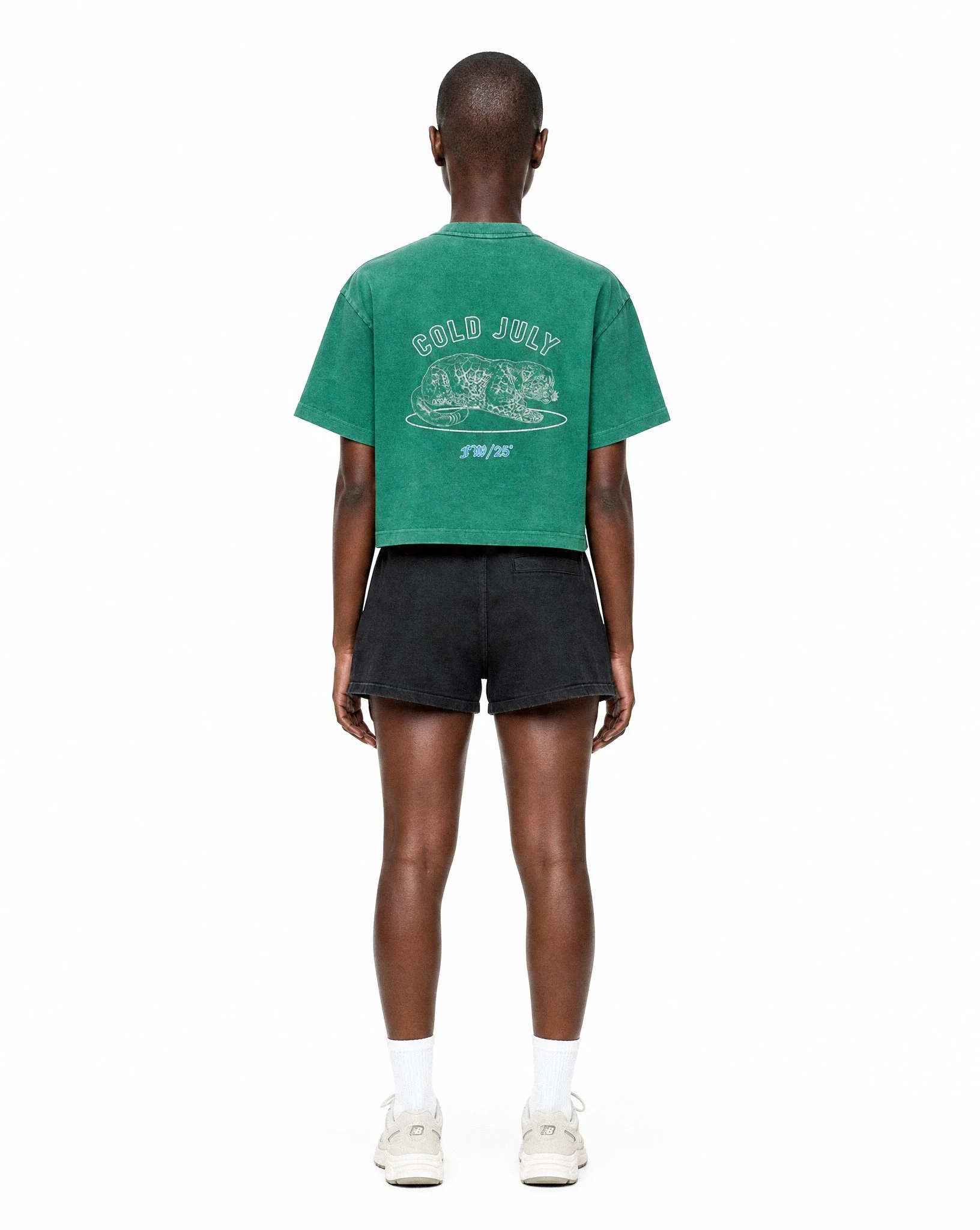 Generated with Kive.ai - Omah wearing the CJ25 t shirt standing facing away from the camera to show the back graphic_ the neckline is nice and tight around the neck_ the tee fits slightly cropped but has a boxy fit in Flat White Studio_ make.jpg