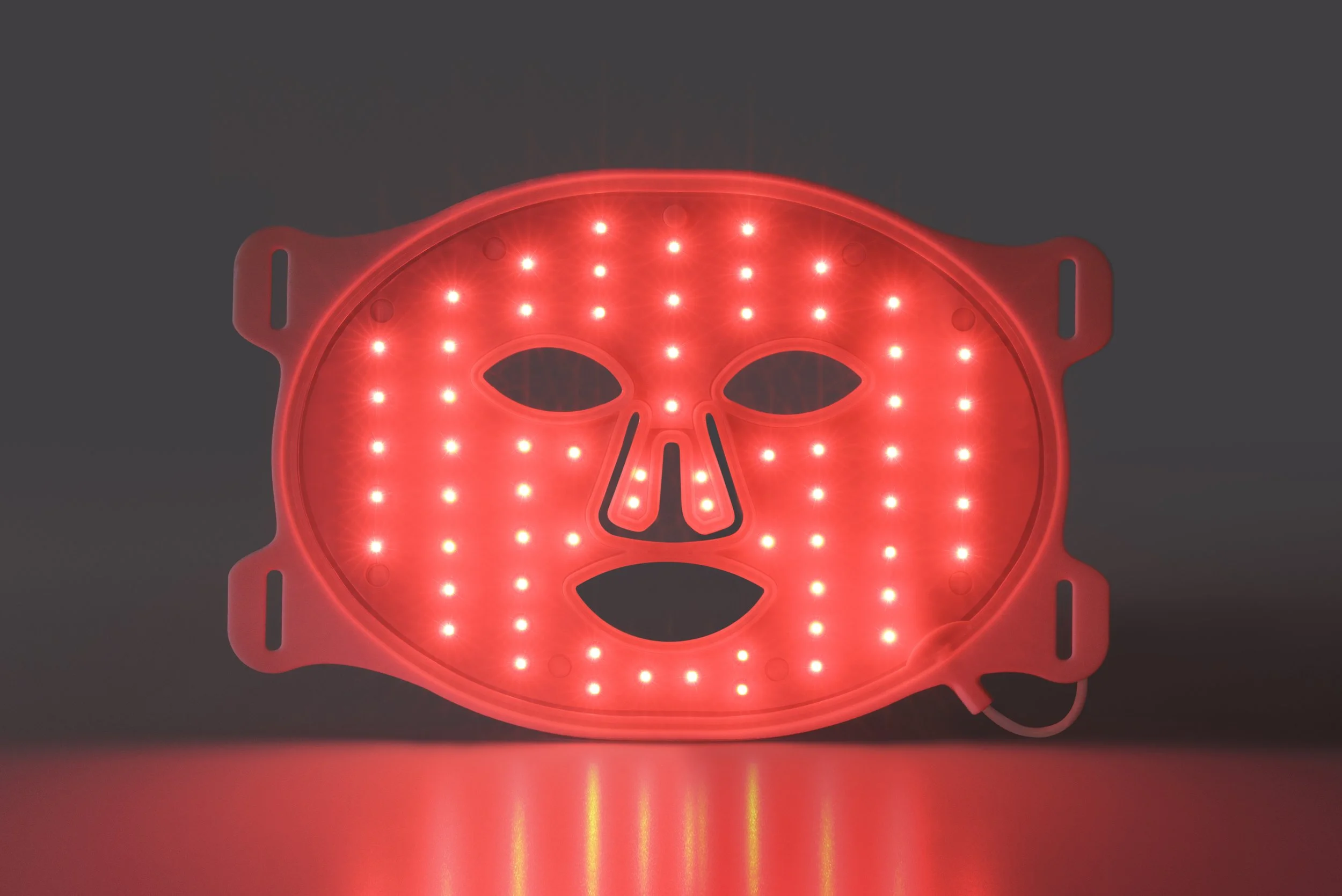 Close-up of illuminate red LED lights inside Omnilux Contour Face mask for collagen stimulation and skin rejuvenation