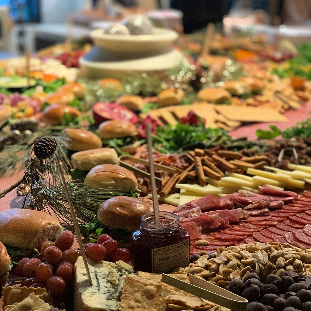 Photo of a full spread grazing table, with meat, cheeses, fruits, vegetables, nuts and so forth.