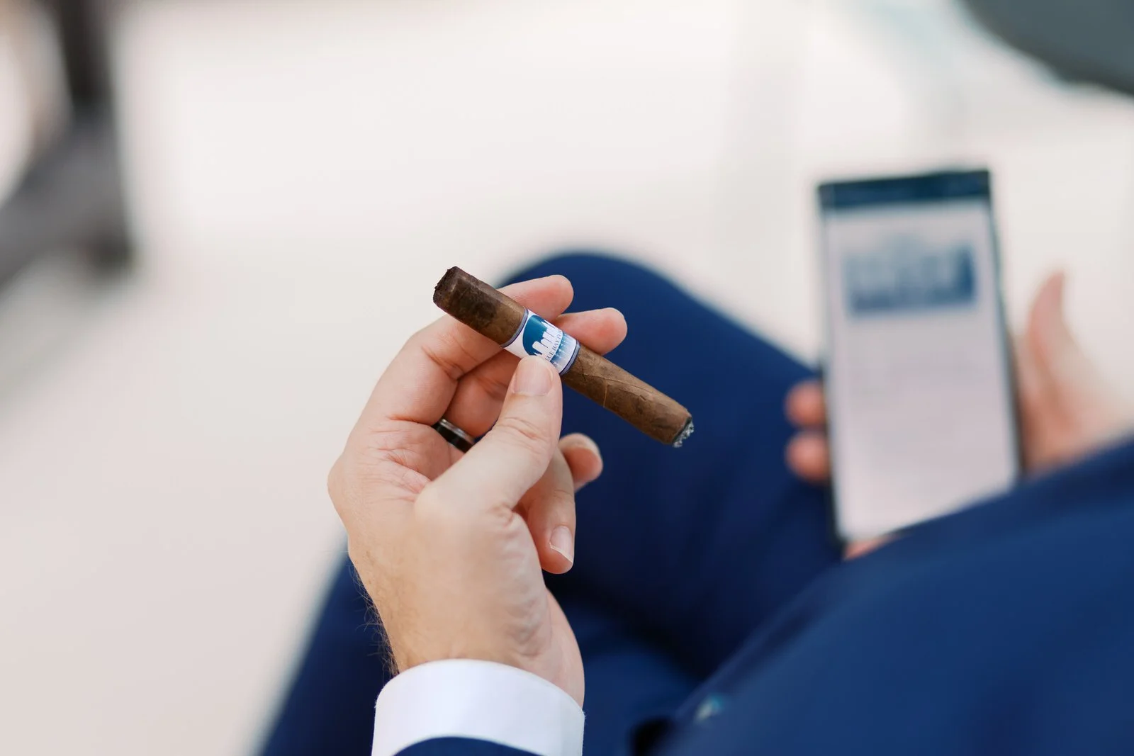Gentleman holding a cigar during a moment of reflection, representing whiskey and cigars for gentlemen, intentional living, discernment, and refined leisure.