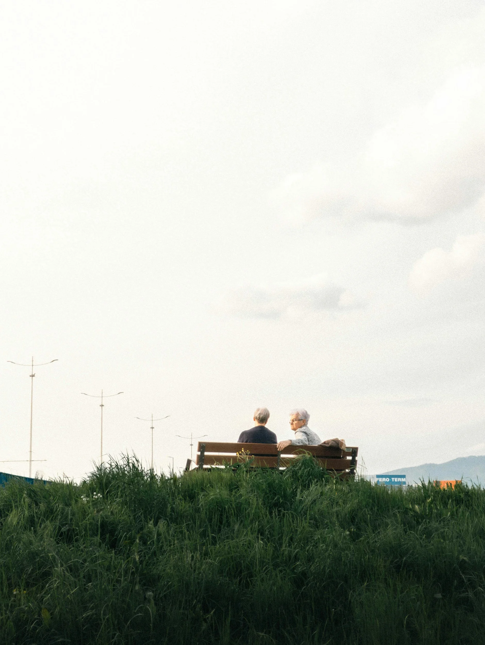 Retired couple sitting on a bench discussing fixed income vs common stock retirement planning