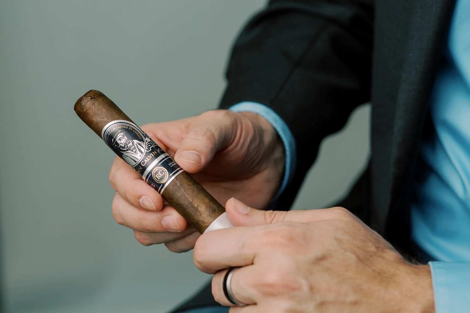 Close-up of a gentleman holding a premium cigar, illustrating best practices for pairing specific whiskeys with cigars and refined tasting rituals.