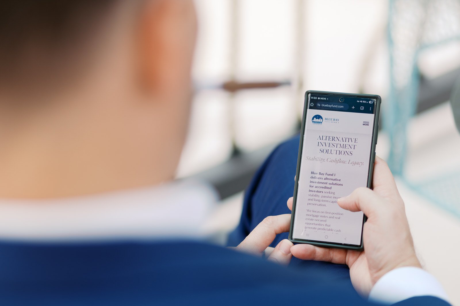 Investor reviewing faith-aligned alternative investment solutions on mobile device, reflecting values-driven real estate private credit and long-term capital stewardship