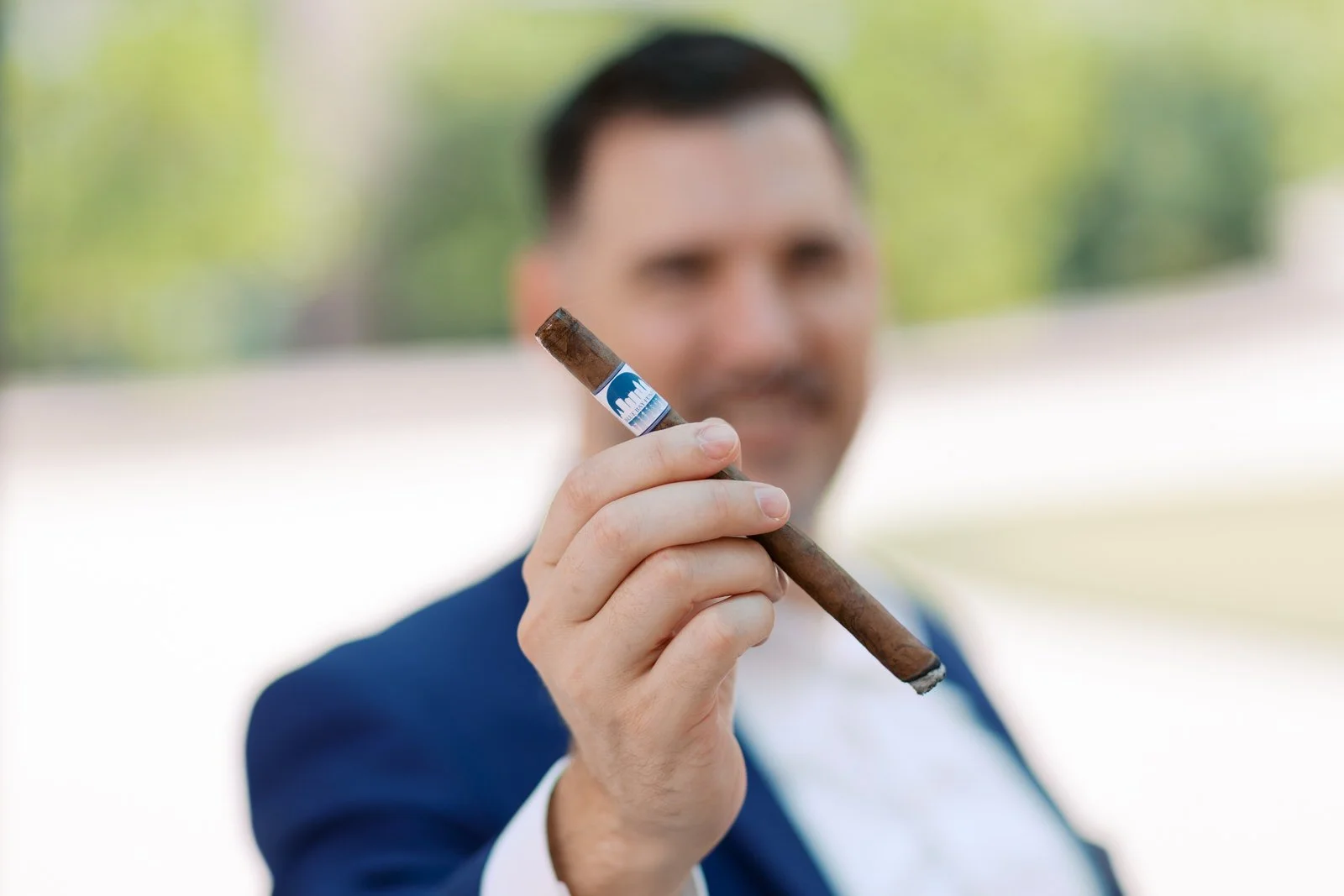 Gentleman holding a premium cigar, representing whiskey and cigars for gentlemen, disciplined leisure, stewardship, and intentional enjoyment.