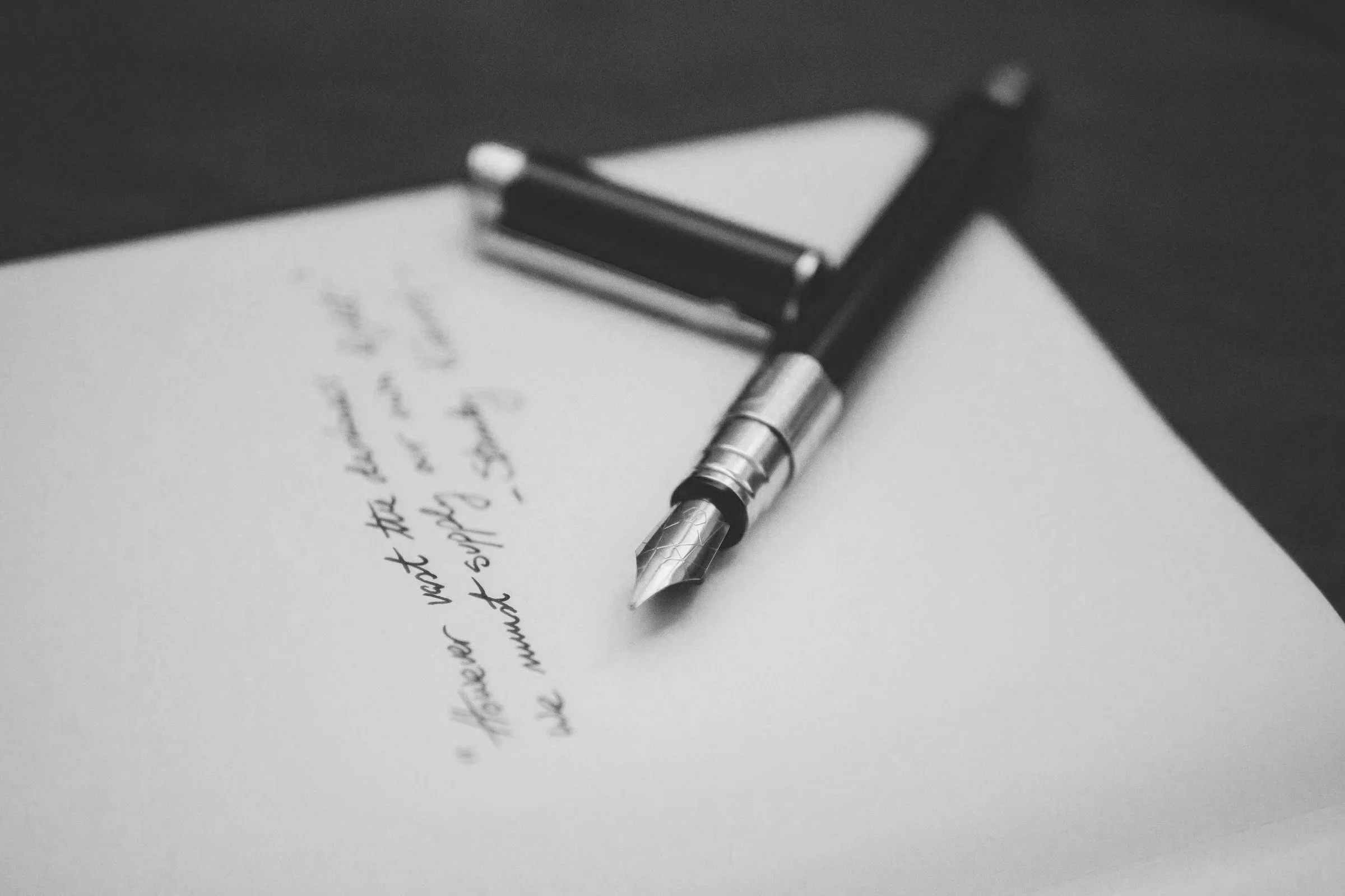 Black-and-white photograph of a fountain pen resting on handwritten notes, symbolizing thoughtful financial planning and exploring alternatives to annuities