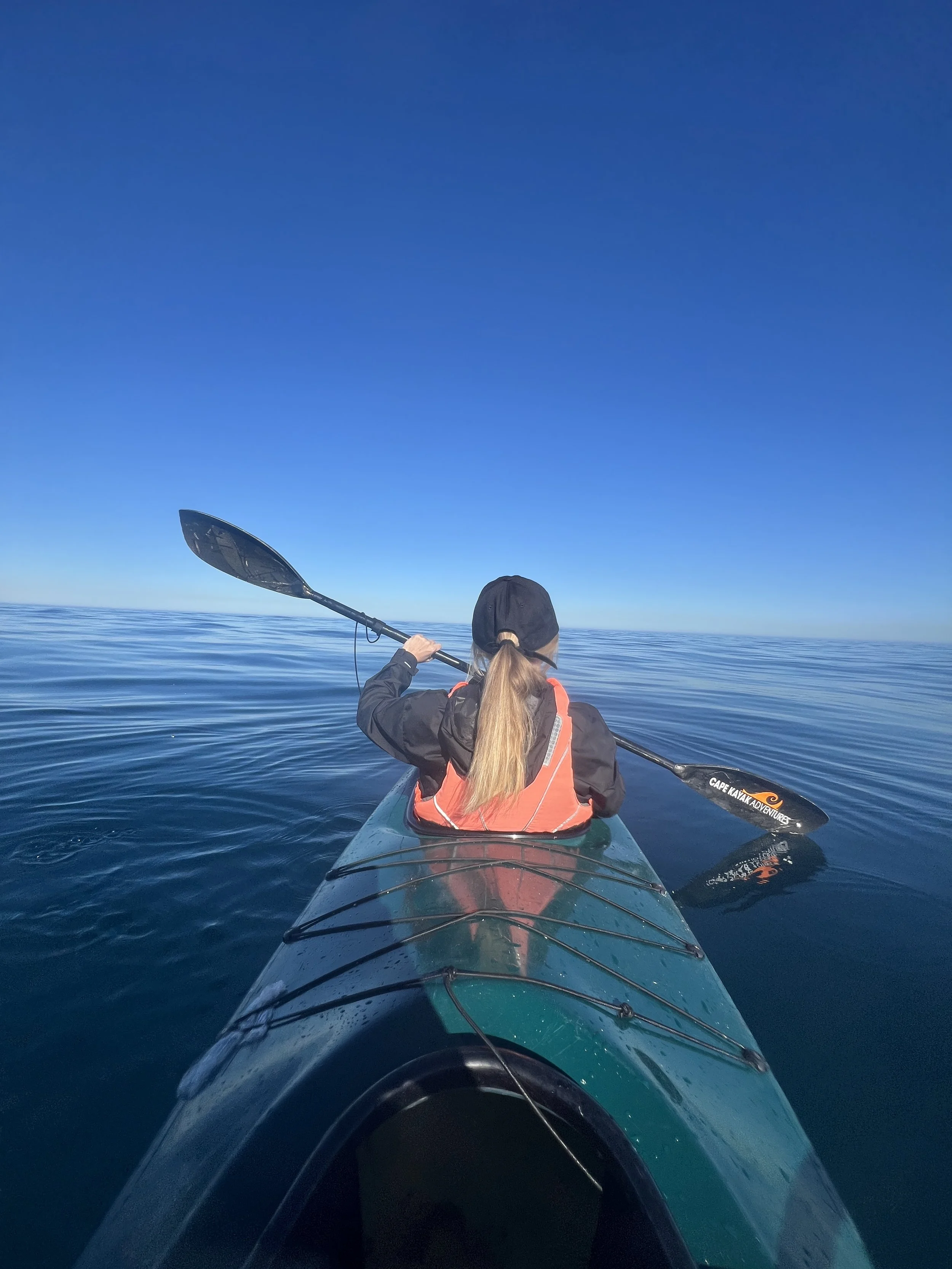 Woman in a kayak, in the water near Table Mountain and Lions Head in Cape Town South Africa off the coast of the V&A Waterfront | Kayaking in Cape Town