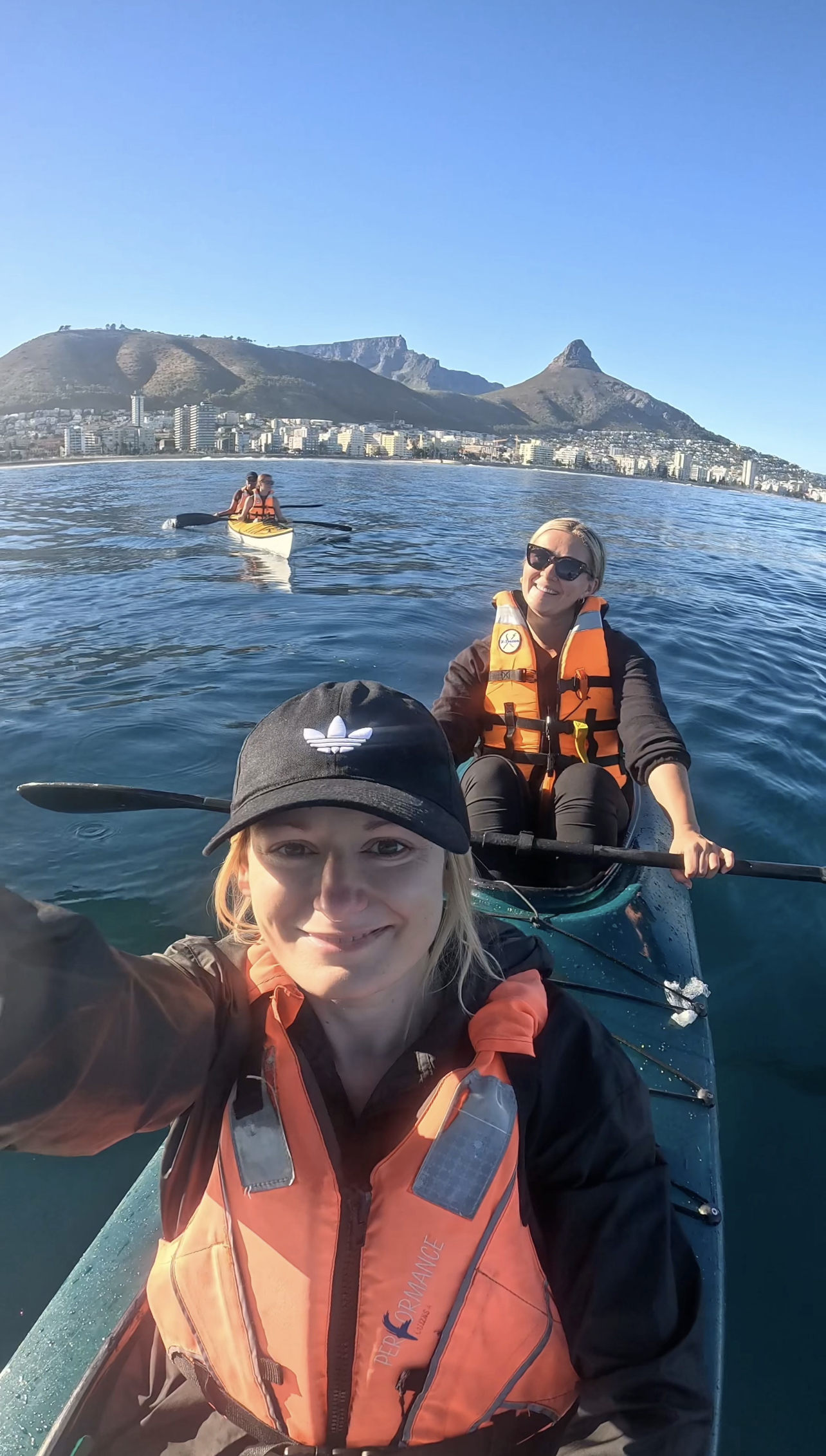 Two women in a kayak, overlooking Table Mountain and Lions Head in Cape Town South Africa off the coast of the V&A Waterfront | Kayaking in Cape Town