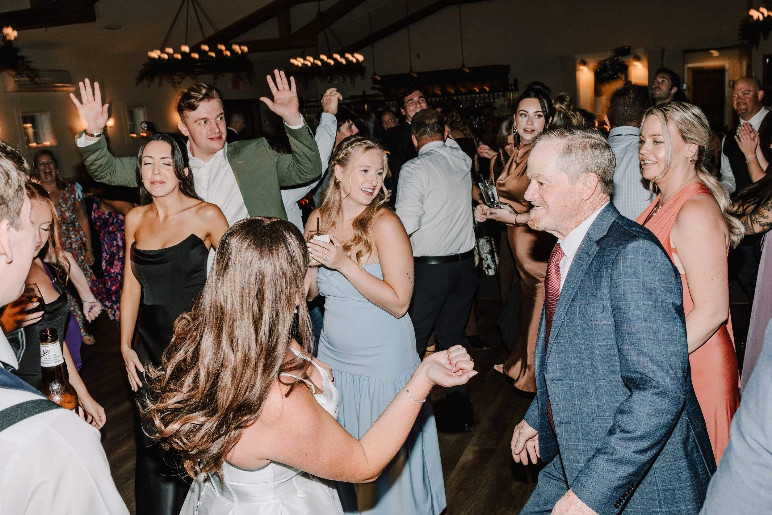 People dancing and enjoying a celebration or party in a decorated indoor venue.