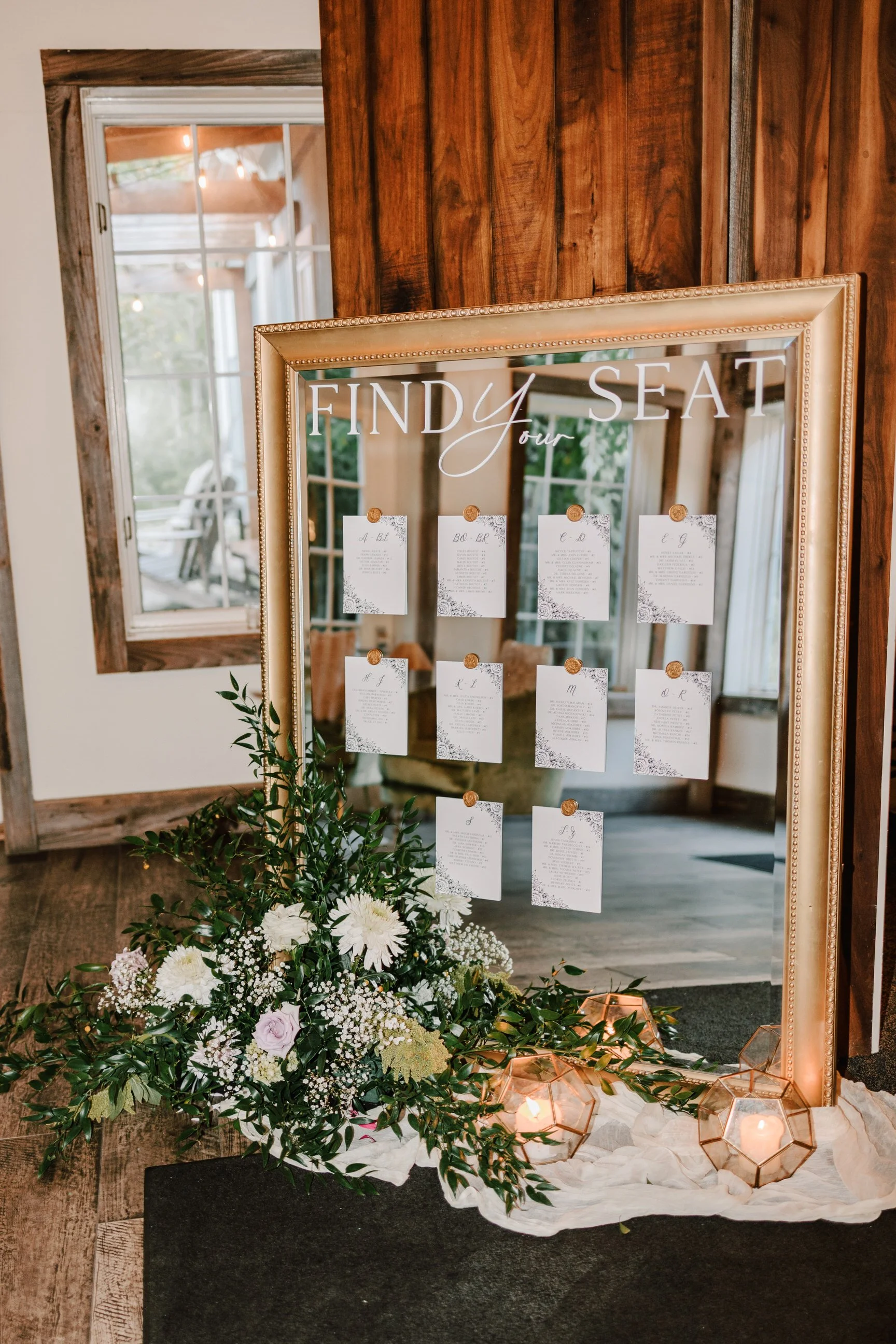 Mirror guest seating chart with floral decoration and candles