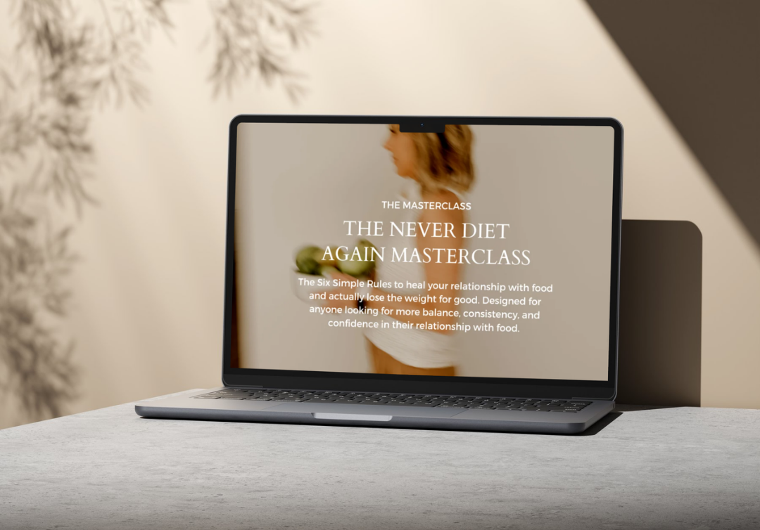 Laptop displaying a masterclass titled 'The Never Diet Again Masterclass' with an image of a Kim Shapira holding an apple and a peach on the screen.