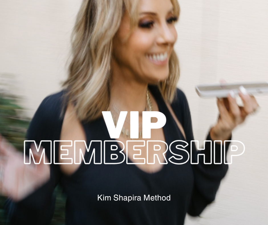 A woman smiling while holding a phone with text overlay that reads "VIP MEMBERSHIP" and smaller text "Kim Shapira Method".