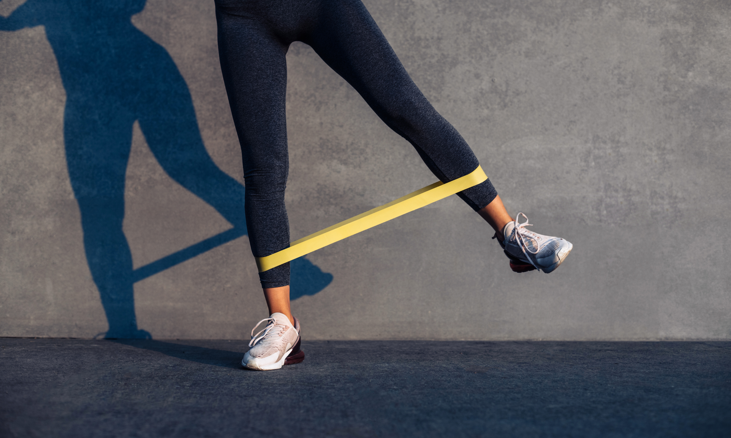 Physiotherapist guiding ankle rehab exercises using resistance bands during LOVE phase recovery.