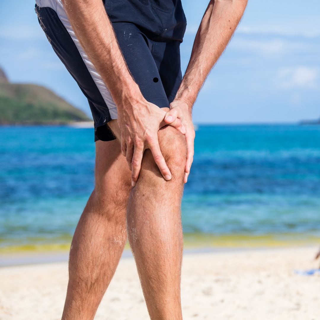 Runner holding knee during summer training on the Sunshine Coast