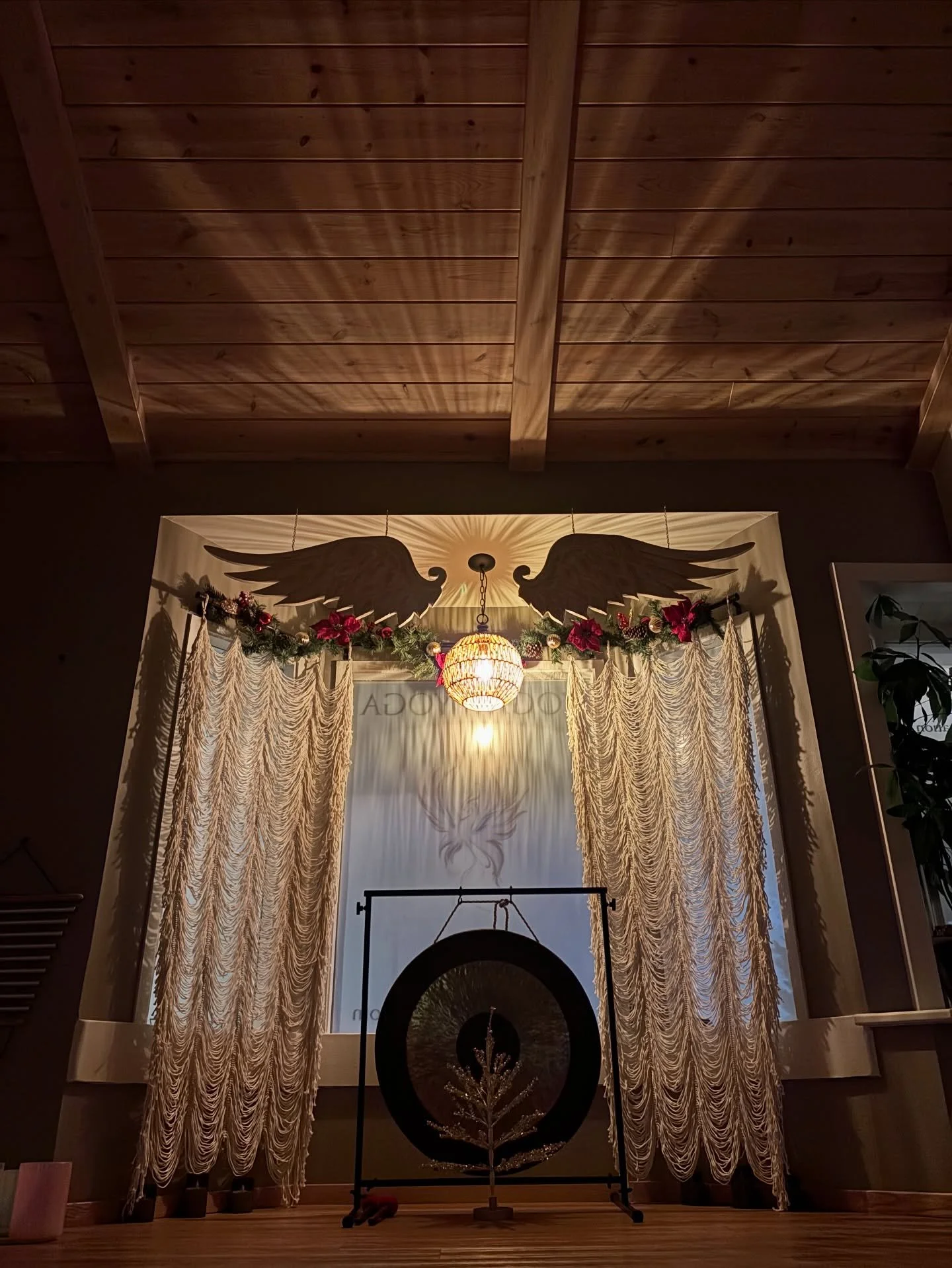 There&rsquo;s something sacred about this space&hellip;the way the light pours through the curtains,
the angel wings holding the room in quiet protection, the gong standing steady at the center like a heartbeat.

This is where we gather to soften. To