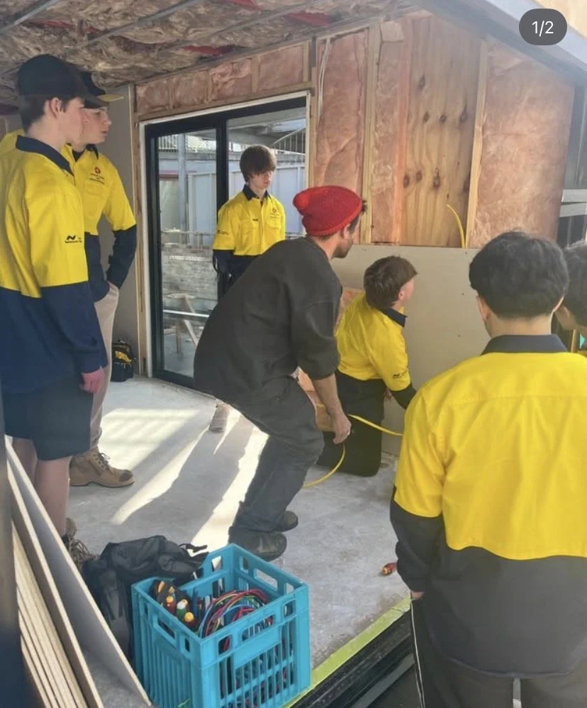 Phil works with Electro students at Elizabeth college to install an EV charger as part of clean energy education project