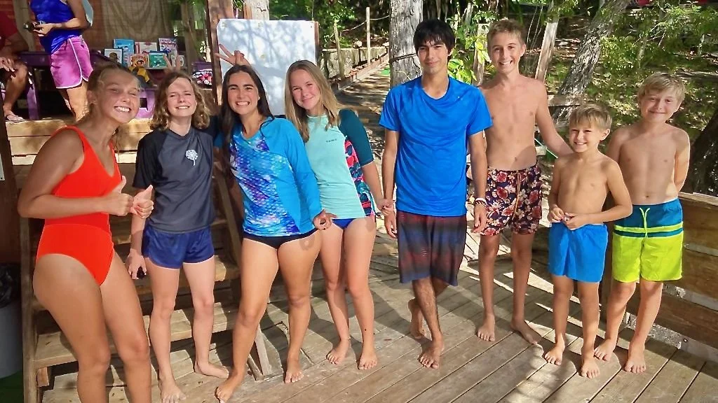 Boats kids posing for a photo ashore in Martinique