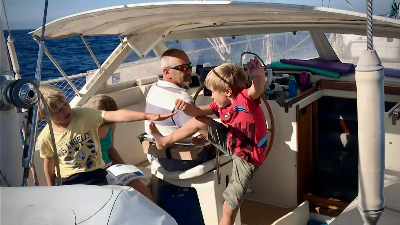 Boys - Yewan and Darry - fighting in the cockpit of a sailboat - S/V Mothership