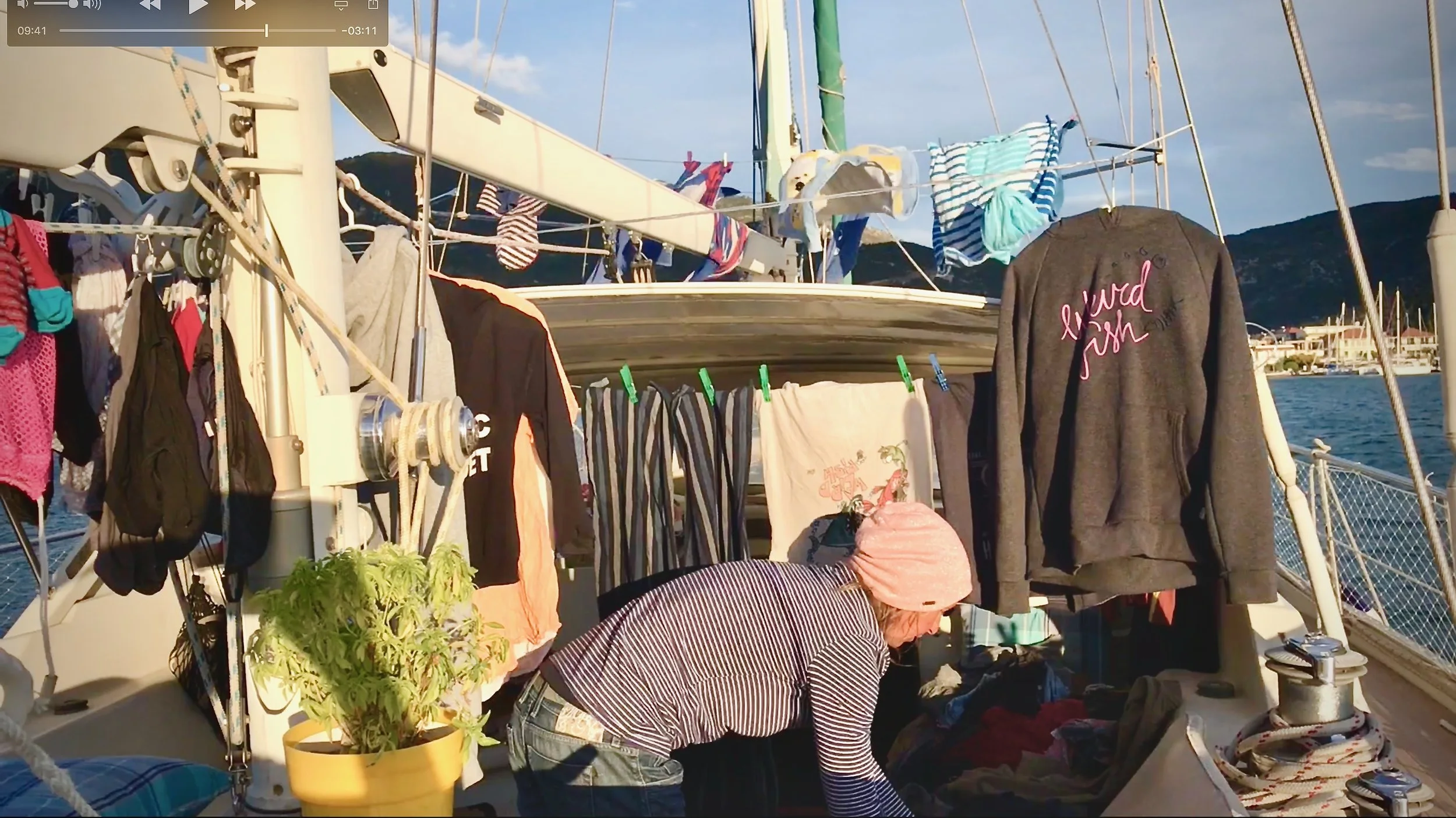Woman - Irenka - hanging out washing to dry in the cockpit of a sailboat - S/V Mothership