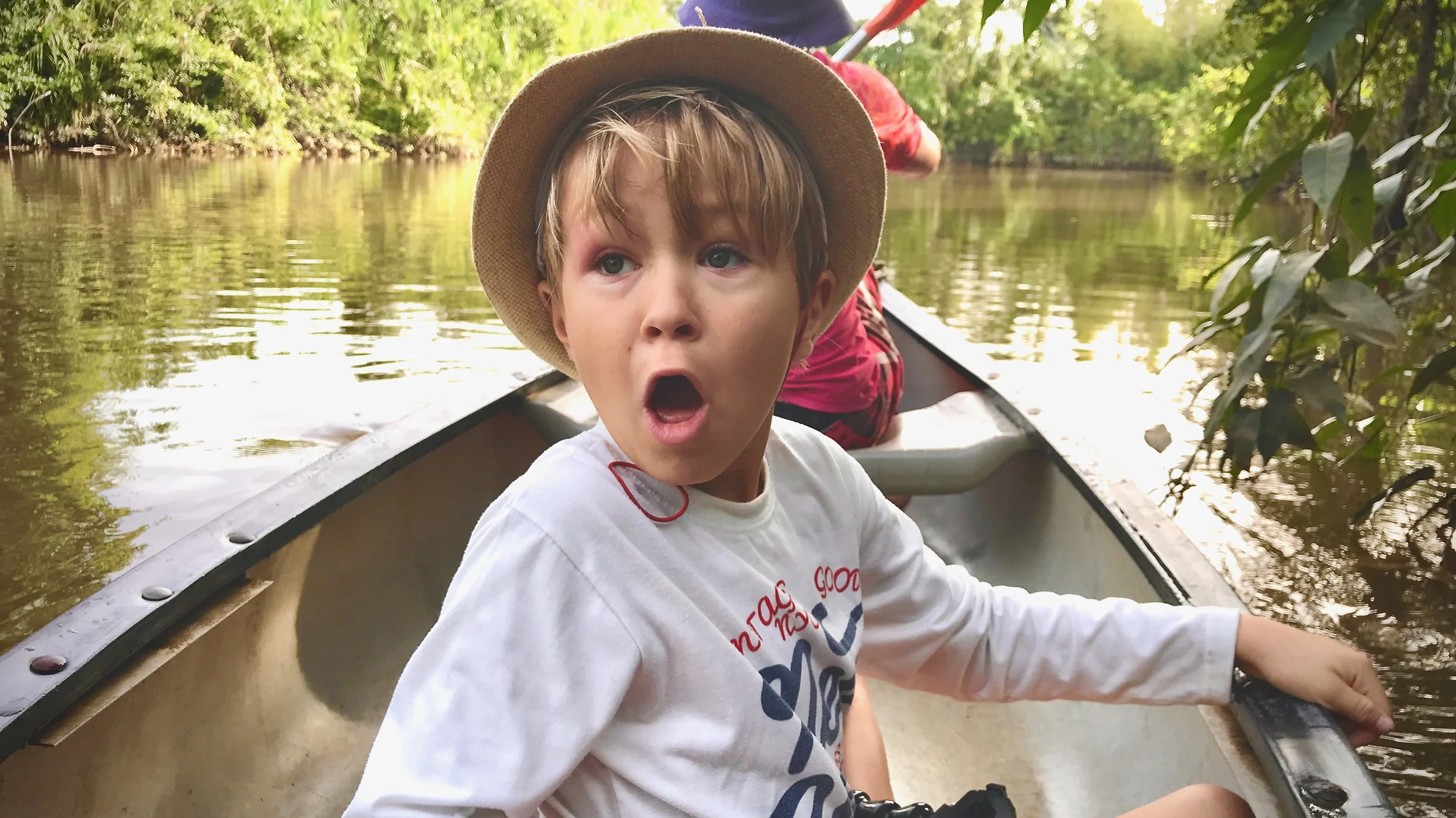 Yewan looking surprised while sat in a canoe in the Suriname River
