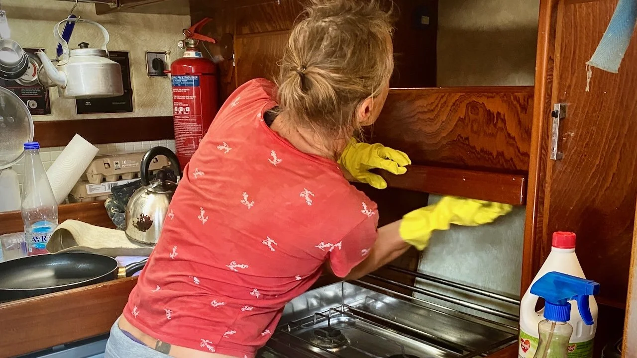 Woman - Irenka on S/V Mothership - cleaning the galley on a sailboat