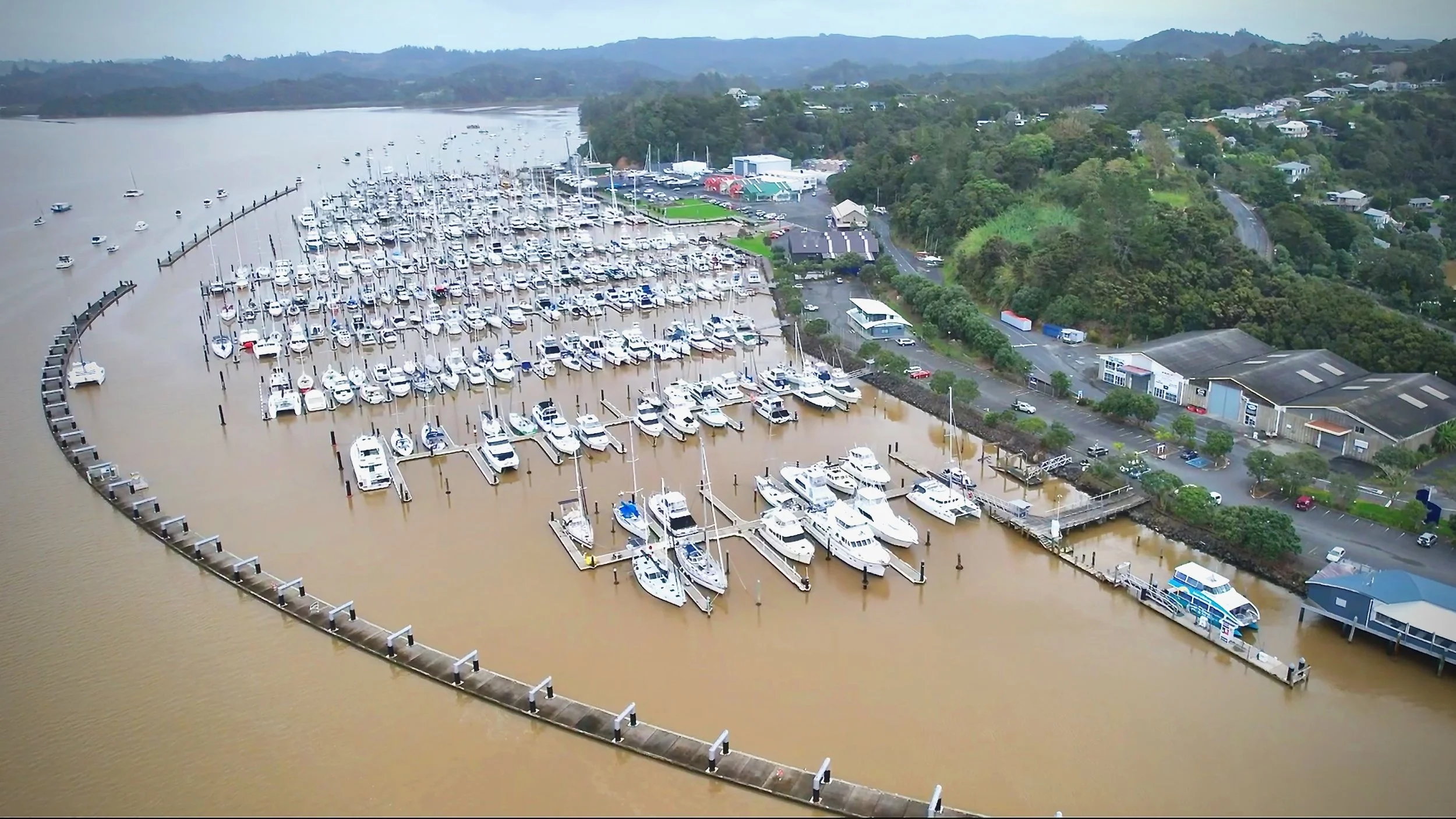 Aerial shot of a coastal bay with sailboats - S/V Mothership and others - at anchor or tied with shorelines