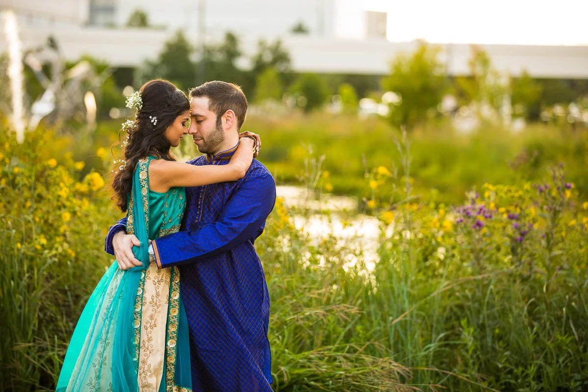 Couple in embrace in front of gardens at Renaissance Schaumburg fusion wedding Sangeet