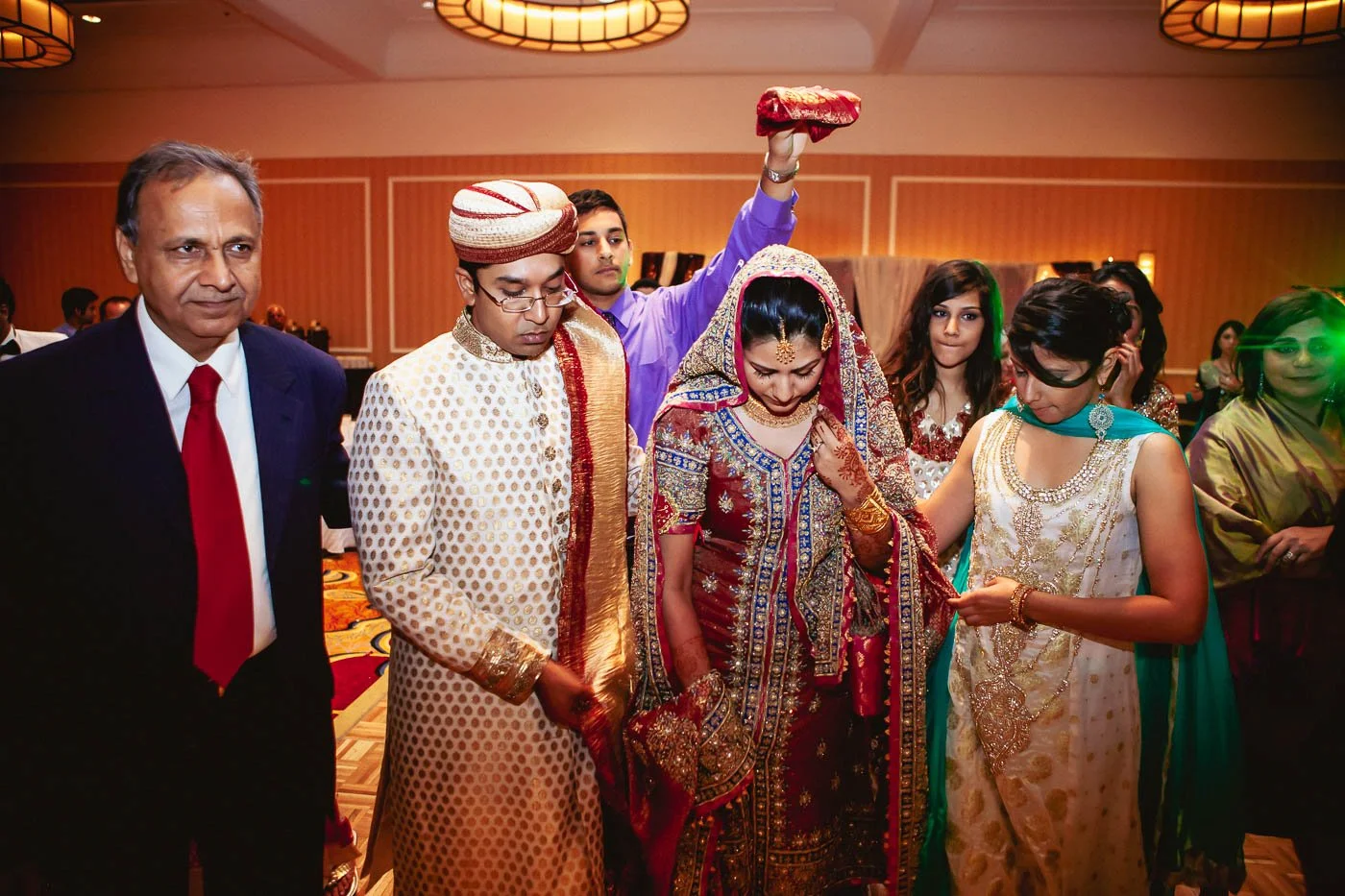 Bride and groom being walked out under quran during rukhsati at St Louis Union Station wedding by Rahul Rana