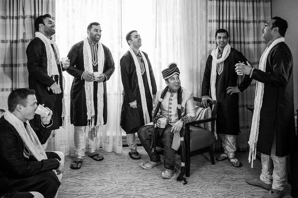 Groomsman wearing kurtas standing around groom talking prior to Gujarati wedding at Chicago Marriott