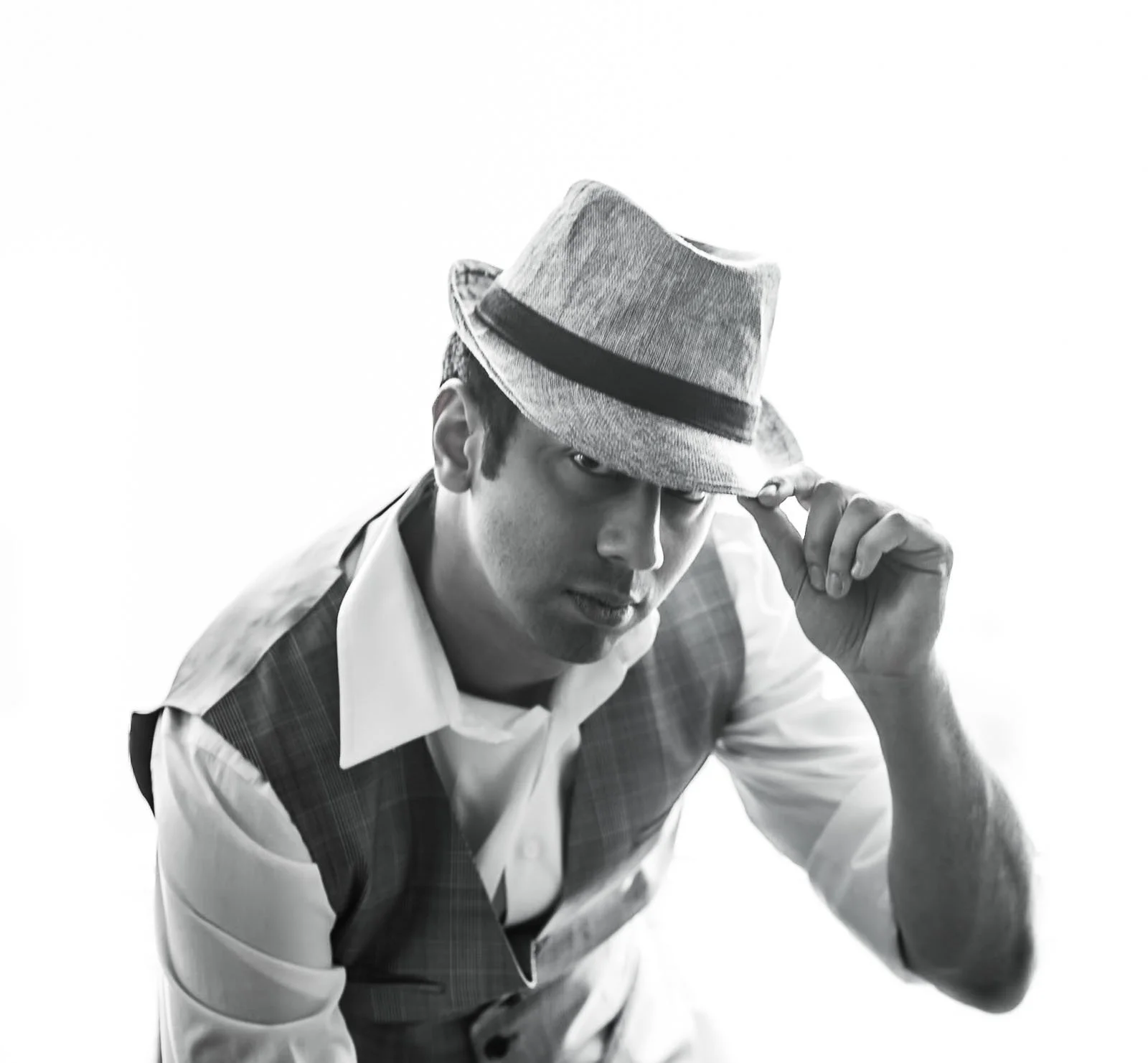 Rahul Rana wearing fedora and checkered vest in black and white photo.