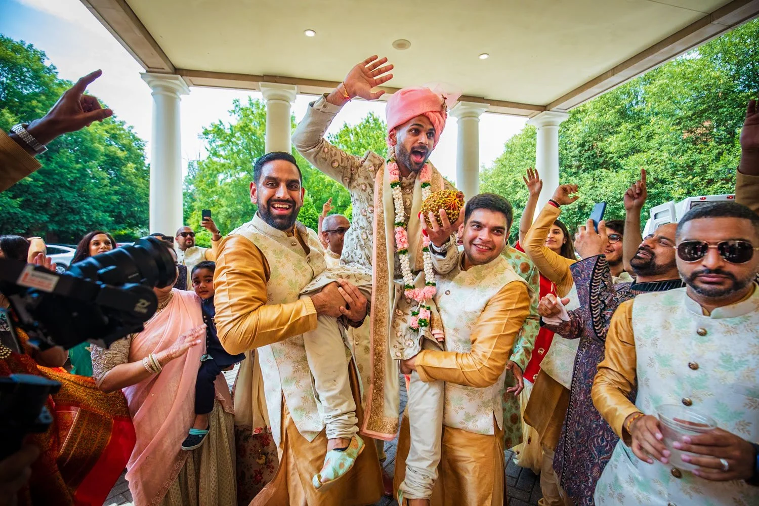 Groom being carried in by groomsmen during baraat at Westfields Marriott entrance