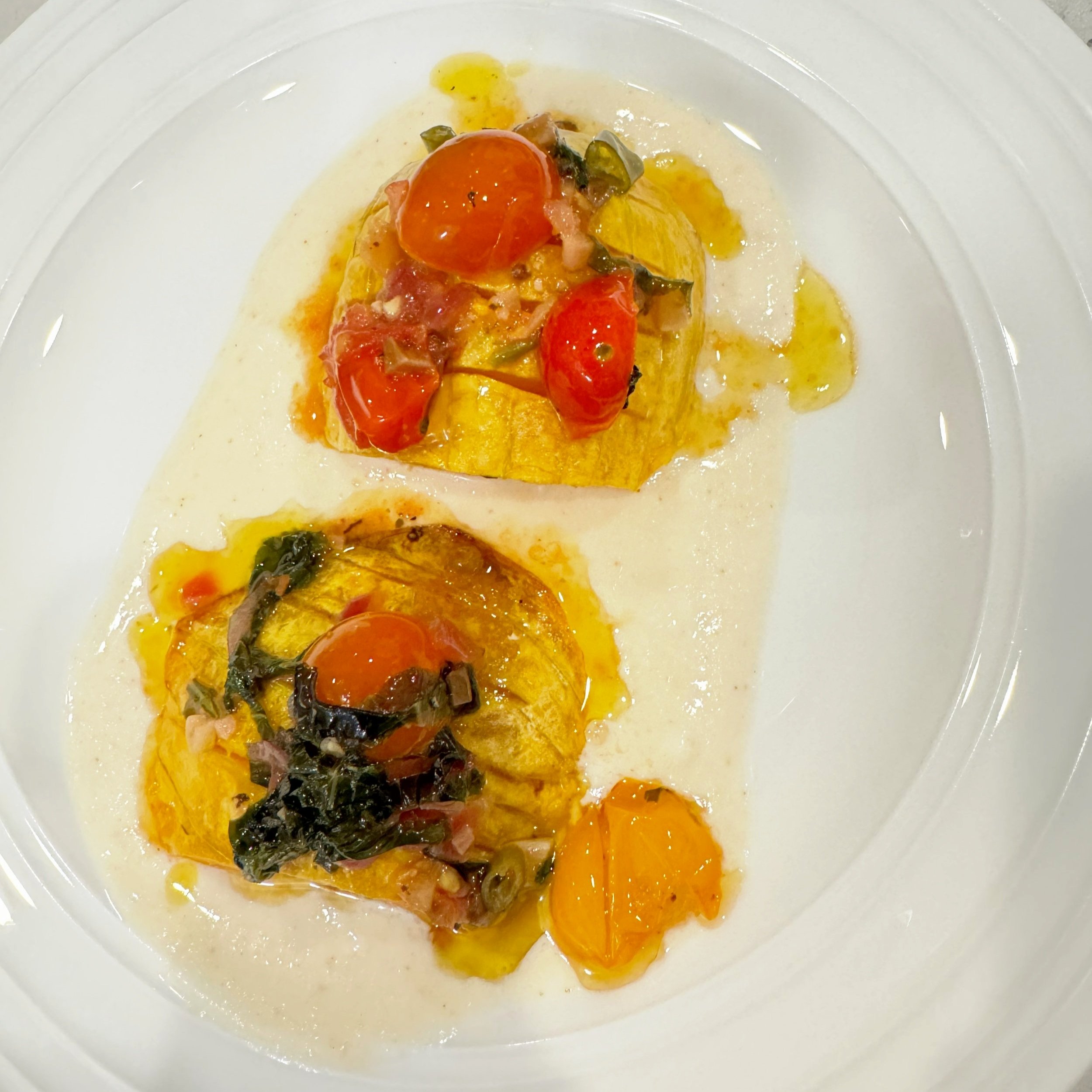 Roasted garlic and hassleback butternut squash topped with garlic butter/ caramelized basil and cherry tomatoes sauce all on whipped feta cheese