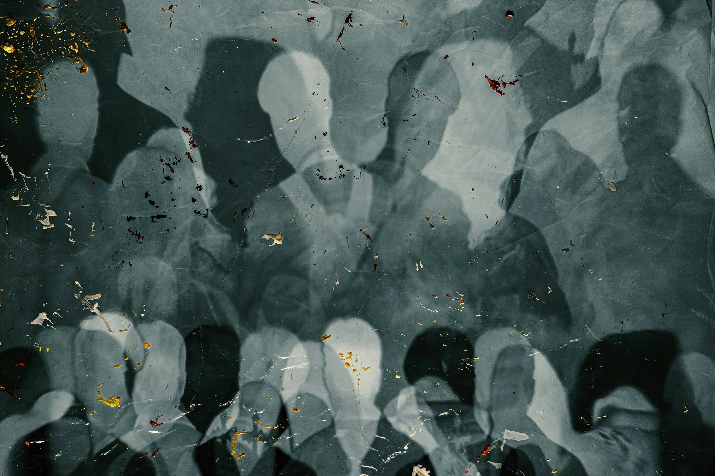 Silhouettes of five people with raised hands, seen through a textured glass surface with cracks and scattered colored leaves.