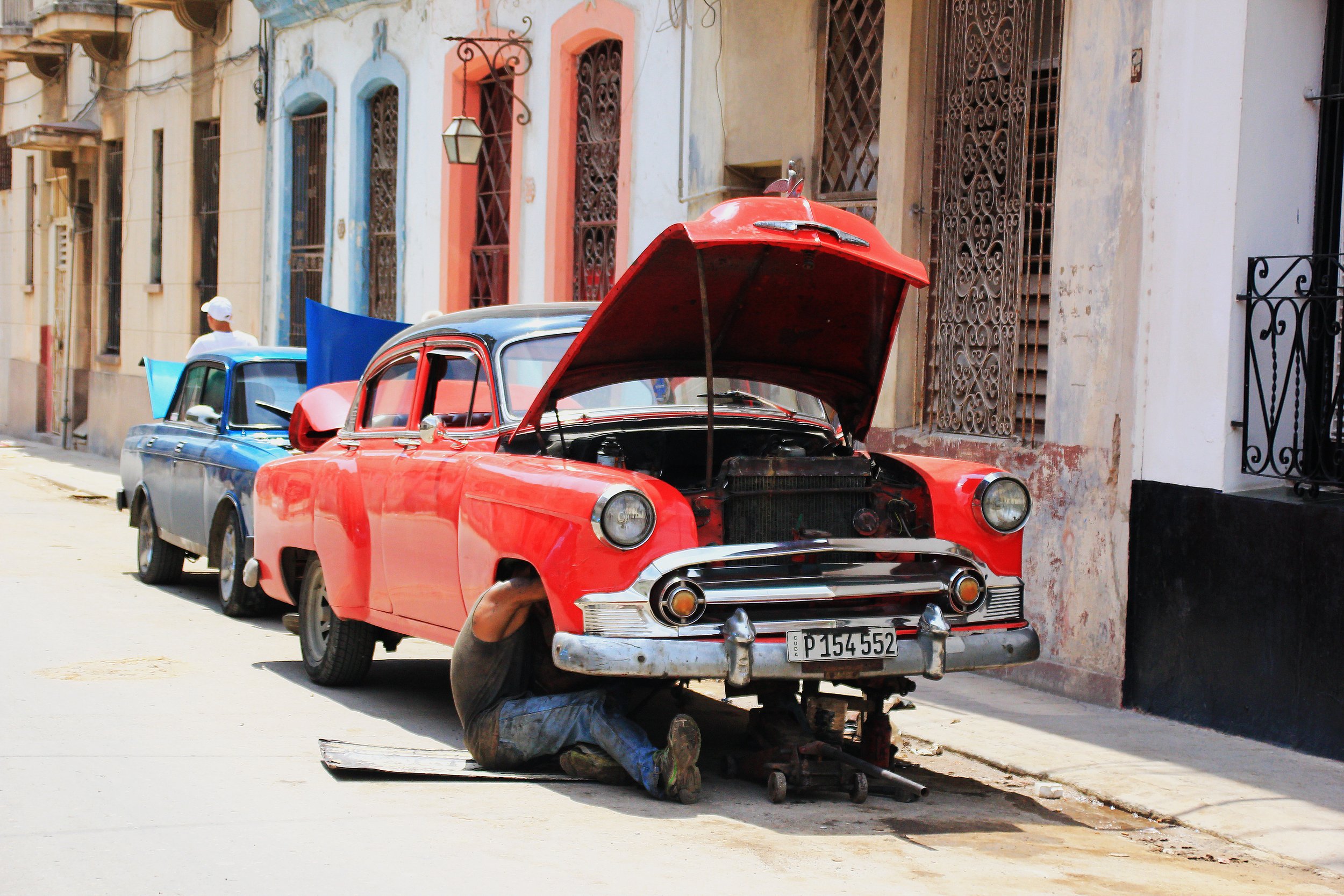 A mechanic in action on a street in Central Havana, fixing a car that may or may not have ended taking foreign travelers around.| Credit: Reynaldo Cruz Diaz