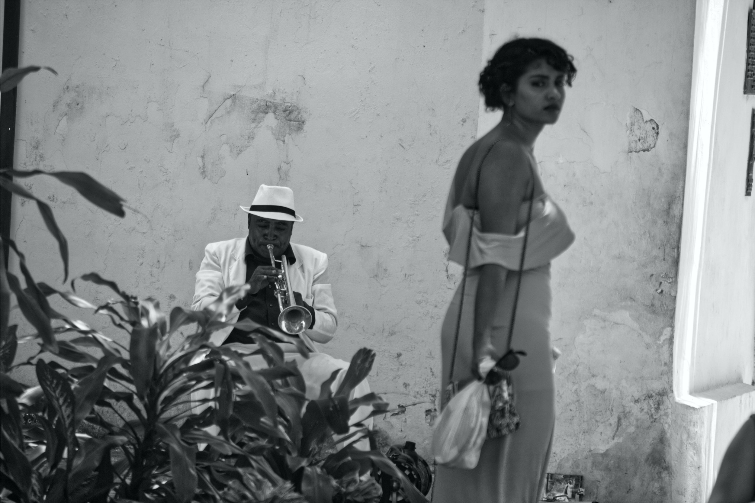 A street musician performs as a young woman walks by.| Credit: Reynaldo Cruz Diaz