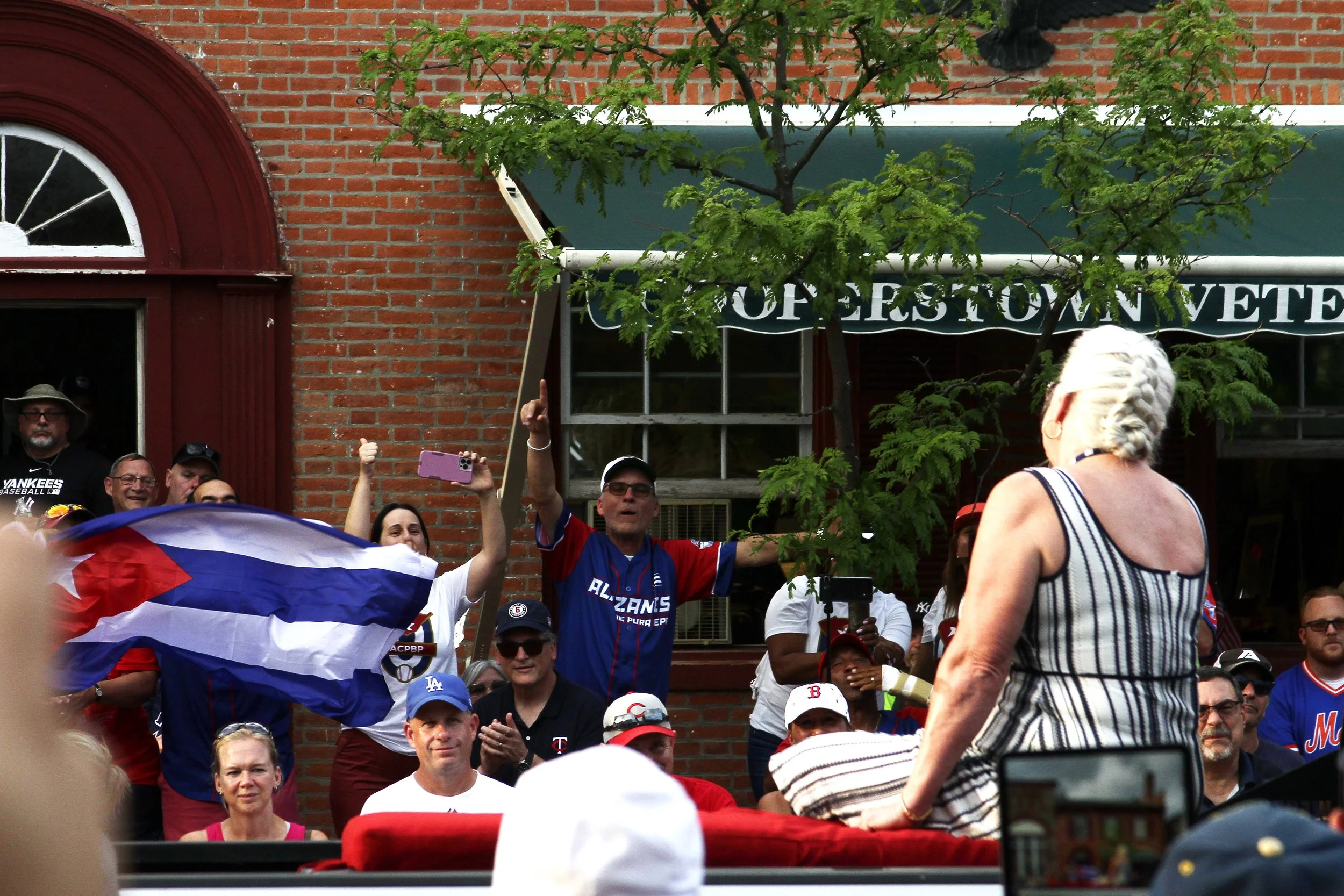 Sharon Miñoso, widow of Cuban Hall of Famer Orestes “Minnie” Miñoso, acknowledges a crowd of Cubans during the 2022 Hall of Fame Weekend parade.| Credit: Reynaldo Cruz Diaz